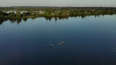 Drone view of people floating on a sub board on a blue lake Stock Footage 155999961
