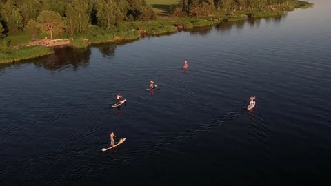 Drone view of people riding on SUP Board at sunset Stock Footage 199805573