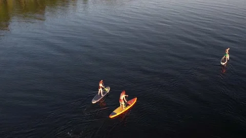 Drone view of people riding on SUP Board at sunset 스톡 동영상 199805653