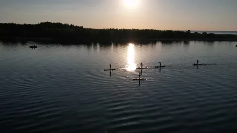 Drone view of people riding on SUP Board at sunset Video stock 199805861