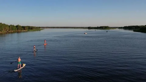 Drone view of people riding on SUP Board at sunset Video stock 199805897