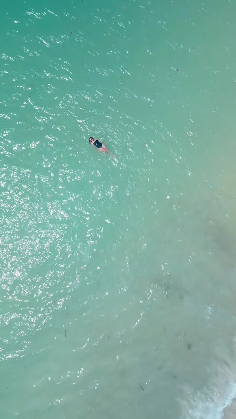 Drone View Person Floating Peacefully In Emerald Water Stock-Footage 334004973