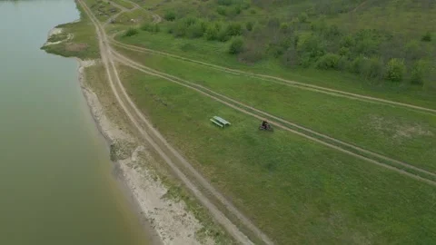 Drone View of Person Riding Away on Motorcycle Near Lakeside Stock Footage 341763204