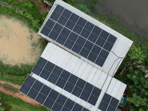 Drone view of photovoltaic solar panels installed on a metal farm roof besi.. Stock Photos