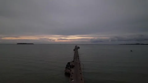 Drone view of the pier road leading to the ocean against the sunset Stock Footage 258321886