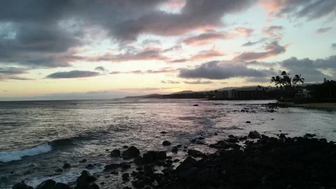 Drone view of pink dusk clouds over a rocky shoreline in Hawaii Stock-Footage 347825860