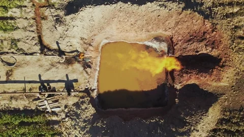 Drone view of pit filled with water. Gas burning. Industrial concept. Gas Stock Footage 219952990