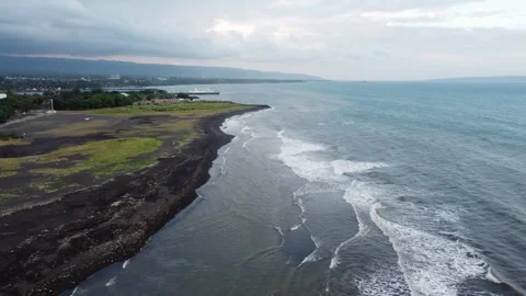 Drone view of plastic waste scattered along a black volcanic sand beach on .. 動画素材 341313348