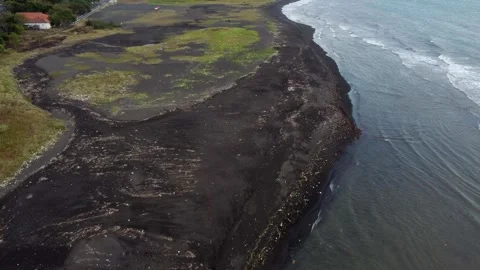 Drone view of plastic waste washed ashore on a black volcanic sand beach in.. 動画素材 341313510