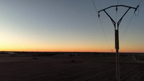 Drone view of a power line in the middle of the field at sunrise Stock Footage 261383775
