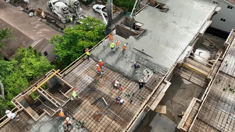 Drone view on pump hose pouring fresh concrete over square reinforcement on new Stock Footage 245959822