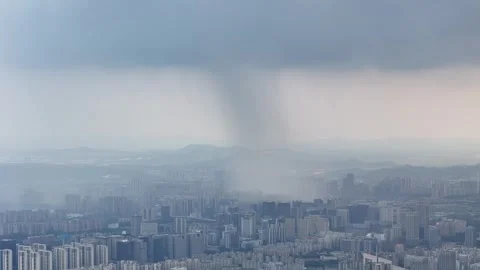 Drone view of rain shaft over city skyline and mountains in China Stock Footage 337767573