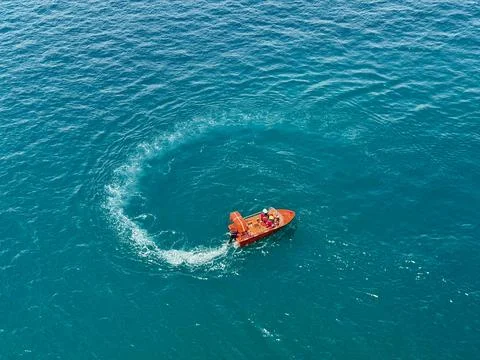 Drone View of Rescue Boat Creating Circular Wake Pattern in Tropical Ocean Stock Photos