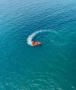 Drone View of Rescue Boat Creating Circular Wake Pattern in Tropical Ocean Stock Photos