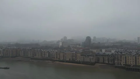 A drone view of residential areas by a river in foggy London. Stock Footage 305432445