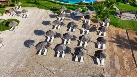 A drone view of a resort's empty white beach with thatched umbrellas. 動画素材 330635895