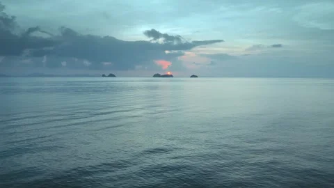 Drone view reveals gentle waves against mountains at pink dawn, serene emblem of Stock Footage 267366588