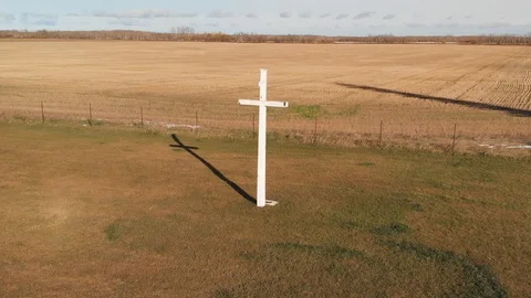 Drone view rising slowly showing a large white Christian cross in a field Stock Footage 118936153