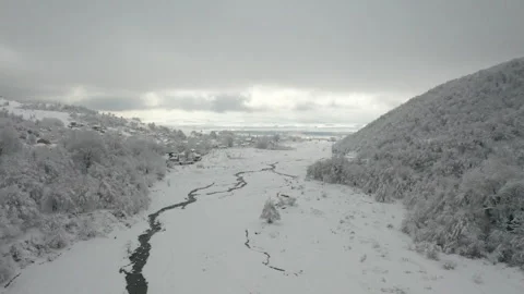 Drone View of River Flowing Between Snow Covered Mountains 動画素材 315875871