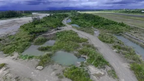 Drone View of River Meandering Beside Remote Jungle Airstrip Under Stormy Sky Stock Footage 318529662