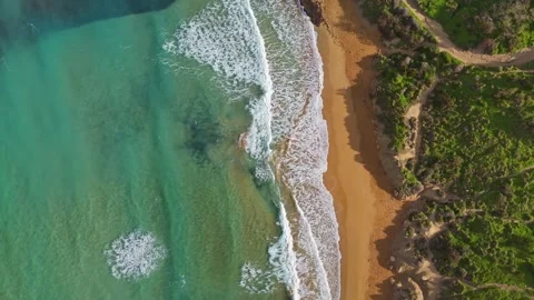 Drone view of Riviera Beach in Malta with turquoise waves, golden sand, and Stock-Footage 330833276