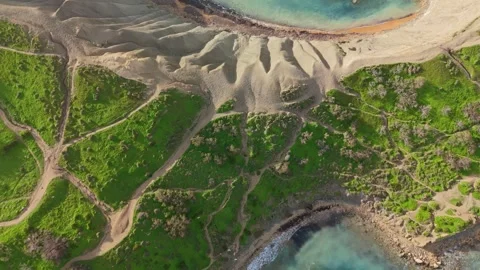 Drone view of Riviera Beach, Malta, with sandy cliffs, green hills, and Video stock 330833313