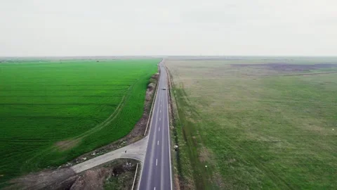 Drone view of a road between green fields Video stock 272993973