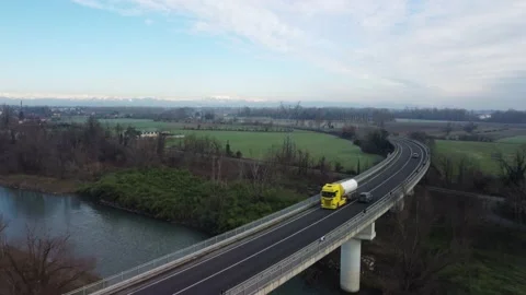 Drone view of a road bridge over a canal with yellow truck and cars. Vídeos de archivo 146338992
