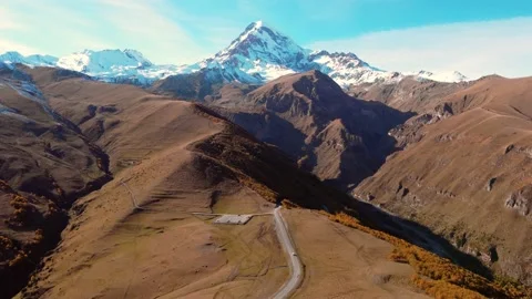 Drone view of road leading to famous beautiful majestic scenery Mount Kazbegi Stock Footage 224946376