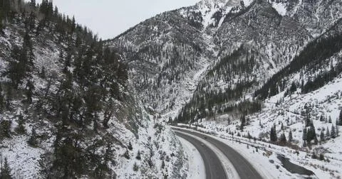 Drone view of a Road Through Snow-Covered Mountains Stock Photos