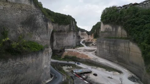 Drone View of Rock Corridor Carved by Excavation at Bali Coastal Cliffs Stockbeeldmateriaal 322892416