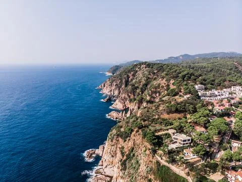Drone view of rocky cliffs and the sea in the city of Tossa de Mar Stock Photos
