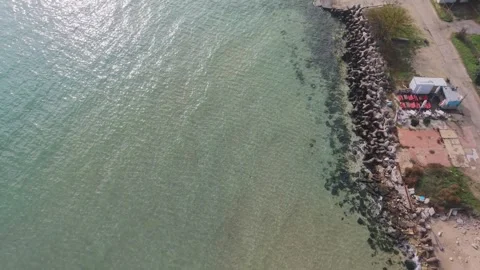 Drone view of rocky seashore with clear water and pier Stock Footage 320990154