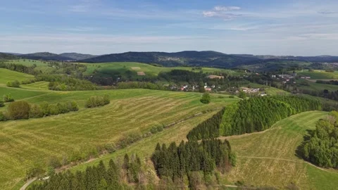 Drone view of rolling patchwork hills, rural fields, winding roads, scattered Stock Footage 346261526