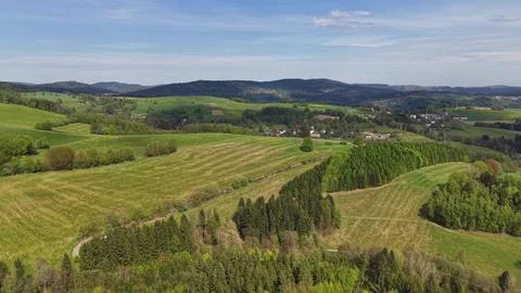 Drone view of rolling patchwork hills, rural fields, winding roads, scatter.. Stock Photos