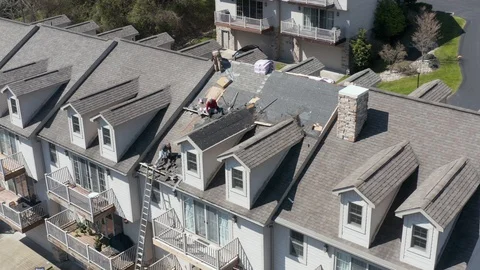 Drone view of roofing contractor removing shingles from a roof ready for Vídeo Stock 128971804
