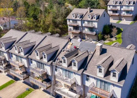 Drone view of roofing contractor removing shingles from a roof ready for Fotos de archivo