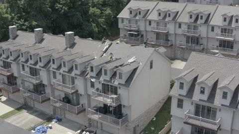 Drone view of roofing contractor replacing shingles and reroofing a townhouse Vídeo Stock 134726663