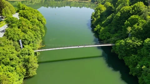 Drone view Rope Bridge over Pasarel dam, water reflection, autumn trees Stock Footage 256034451