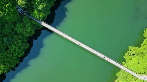 Drone view Rope Bridge over Pasarel dam, water reflection, autumn trees Stock Footage 256034461