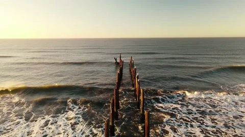 Drone view of a ruined dock hit by the waves at sunrise. Stock Footage 151428436
