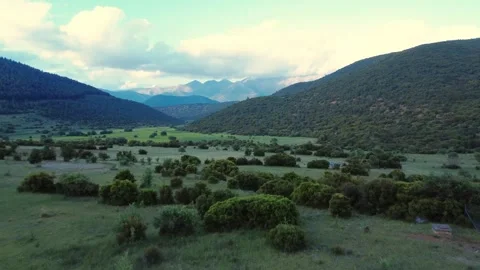 Drone View of Rural Landscape with Low Vegetation and Distant Mountain Peaks Stock Footage 312073708