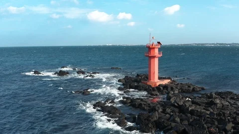 Drone view. Scenery with wild waves and red lighthouse. Arc shot. Jeju Island in Stock Footage 122271789