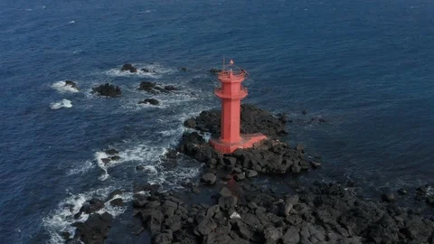 Drone view. Scenery with wild waves and red lighthouse. Arc shot. Jeju Island in Stock Footage 122272074