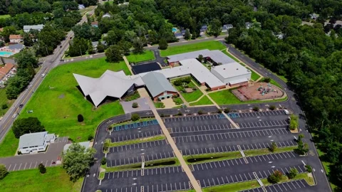 Drone view of a school building and large empty parking lot in Jackson, New Stock Footage 344908687