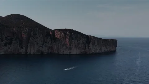 A drone view of sea cliffs and a small boat in the deep blue water, Sardinia Stock Footage 287884778