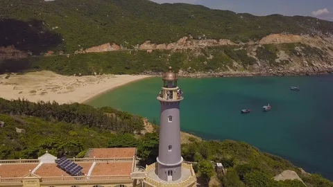 Drone view sea lighthouse on mountain cliff and sailing ships. Aerial landscape Stock Footage 94937996