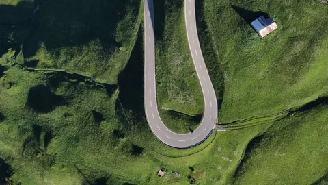 Drone view of serpentine road surrounded by green fields in Switzerland.mp4 Stock Footage 115973427