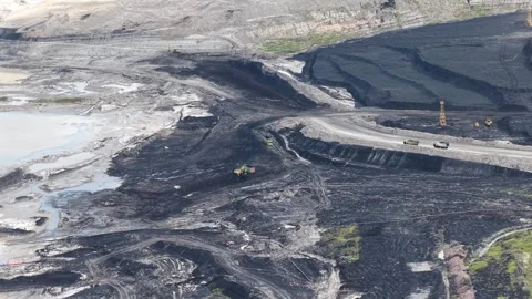 A drone view showing a coal mining site with coal hauling trucks operating .. Stock-Footage 343245716