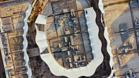 Drone view shows a large building complex with unique roof structures in a dry Stock Footage 341392484
